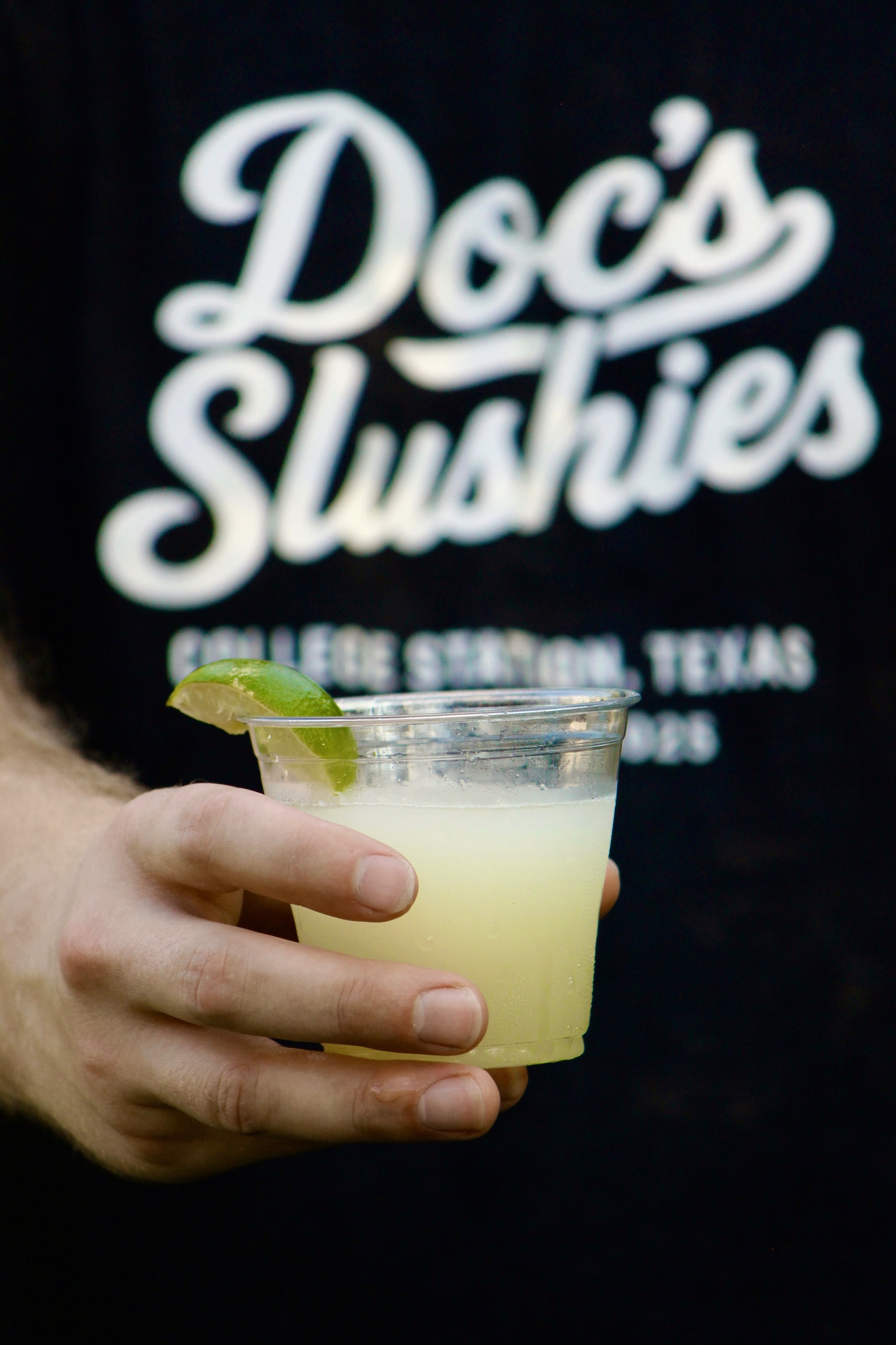 A Doc's Slushies branded cup held up