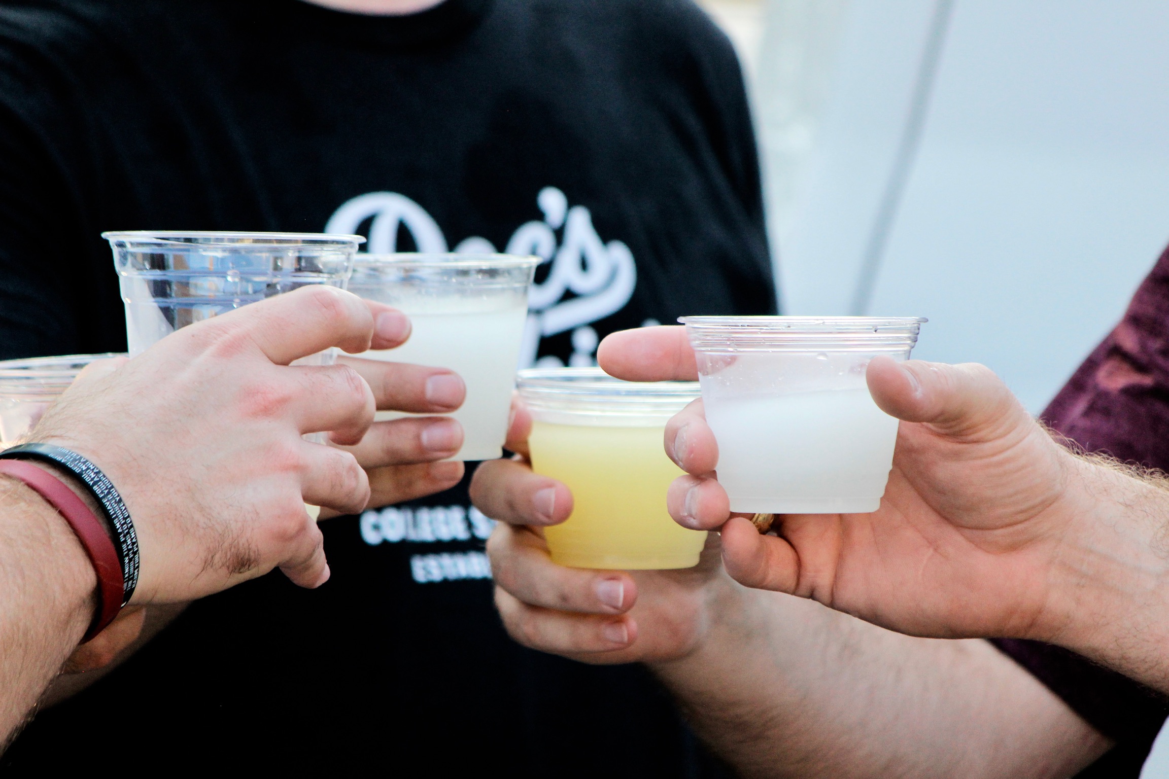 Friends toasting with Doc's Slushies cups